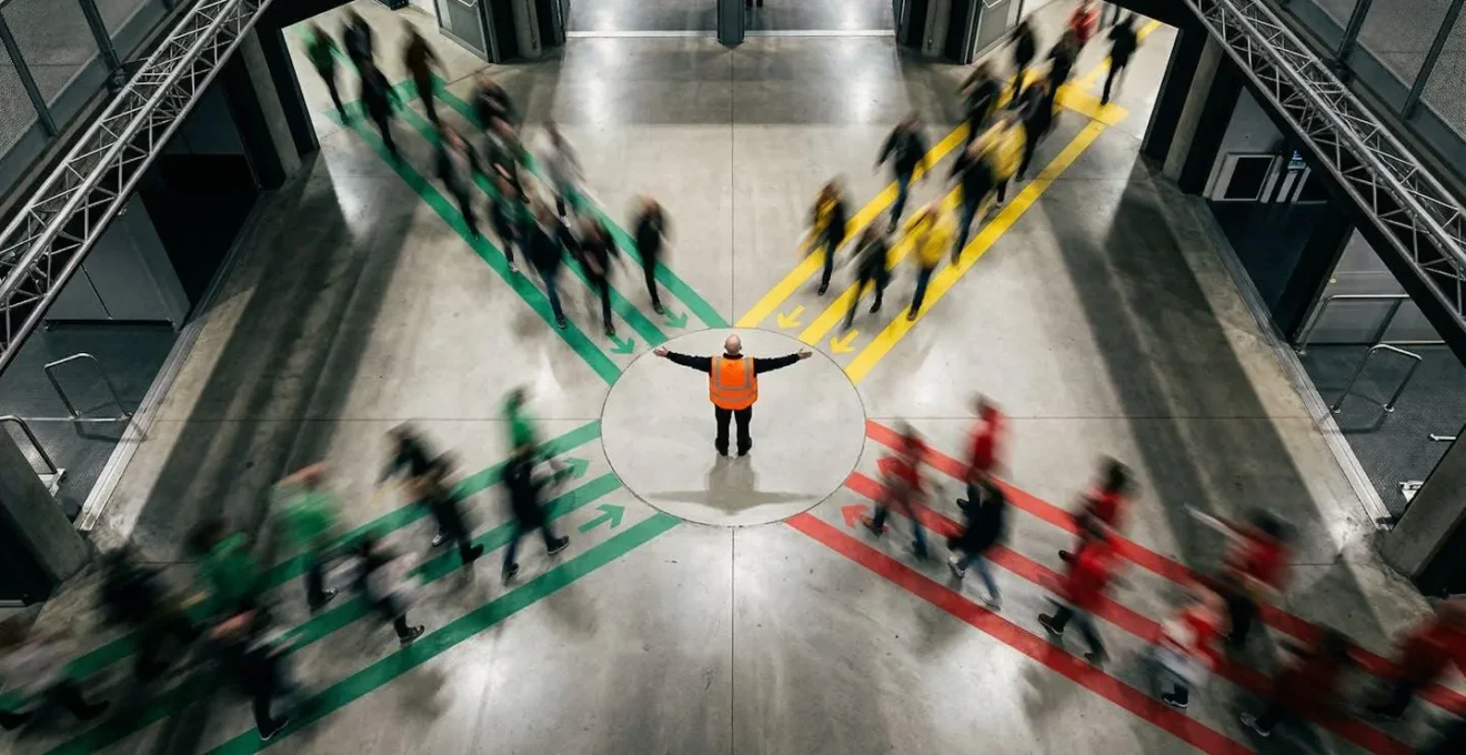 Vue aérienne d'un plan d'évacuation avec agent SSIAP coordonnant les flux