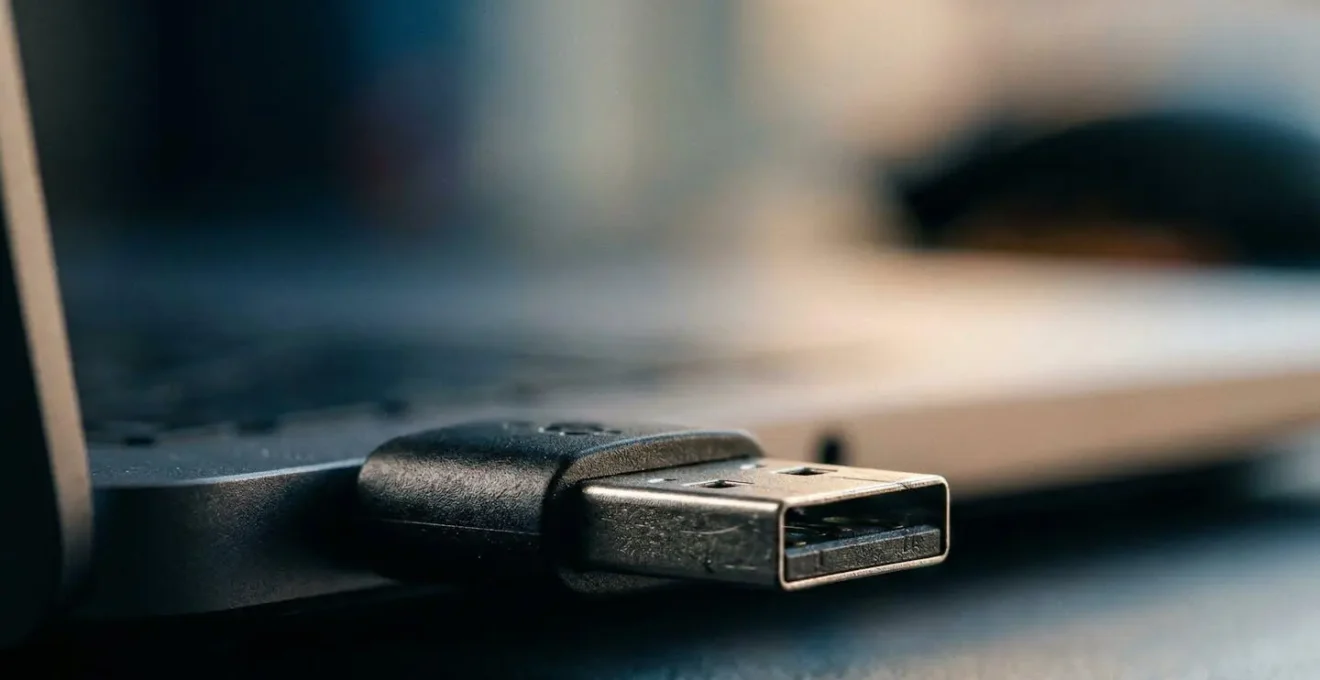 Gros plan sur une clé de sécurité physique connectée à un ordinateur portable dans un environnement professionnel
