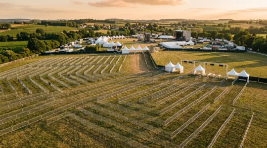 Vue aérienne d'un dispositif de sécurité événementielle avec barrières métalliques et zones de filtrage pour un festival