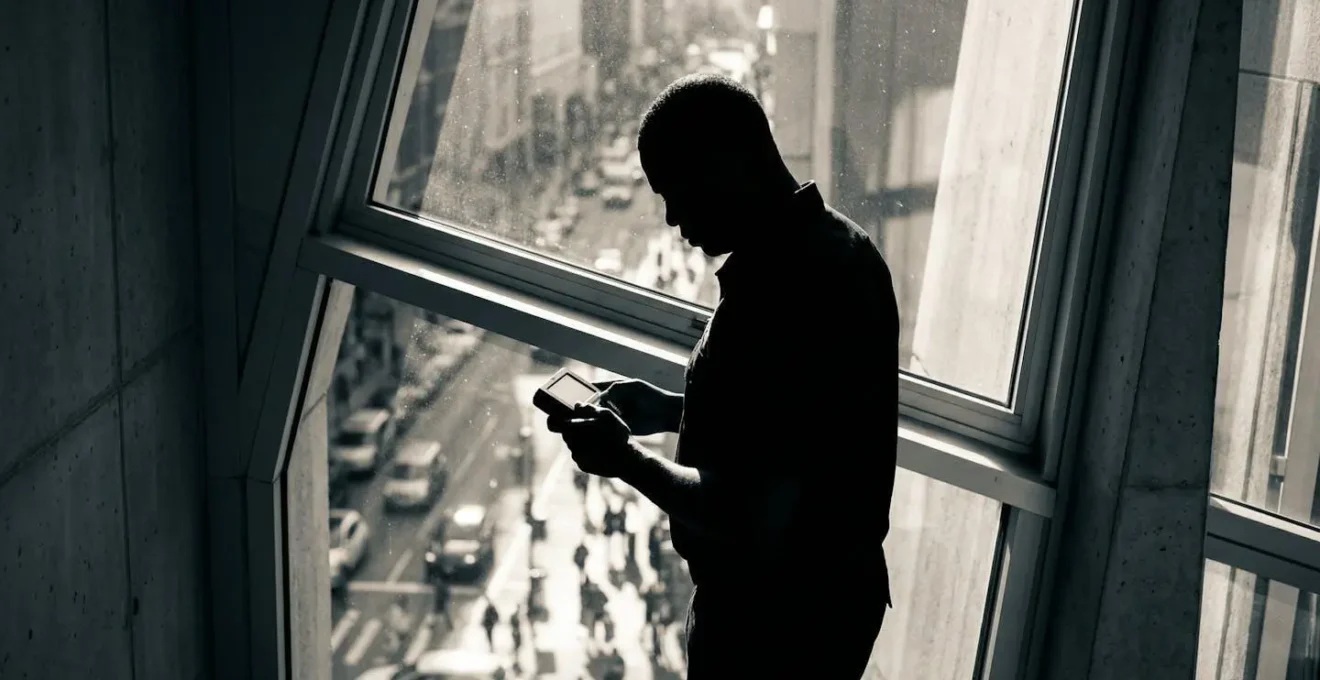 Agent de sécurité en position d'observation filmant discrètement une situation depuis un point surélevé