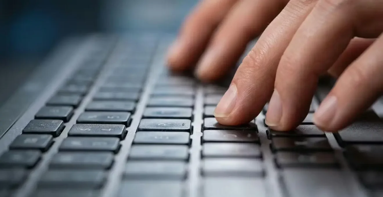 Processus de vérification en ligne sur interface moderne, vue macro des mains sur clavier